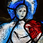 Detail of an angel playing a musical instrument in the window in the north wall of the chancel